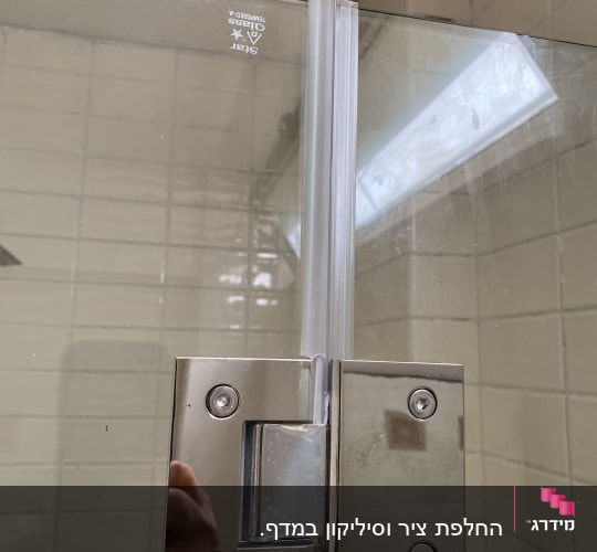 ציר מתכת ודלת זכוכית במקלחת
